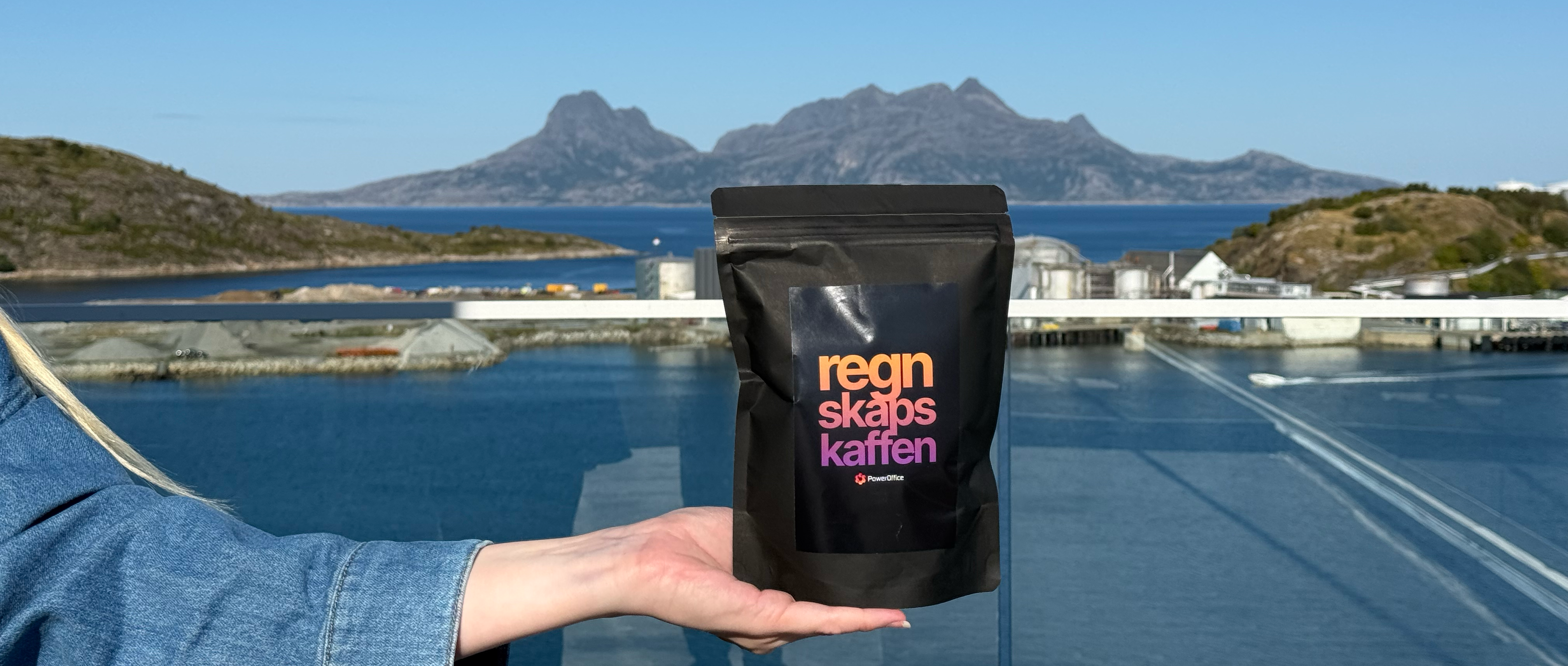 Bilde av en pose regnskapskaffe med havet og Landegode i bakgrunnen.